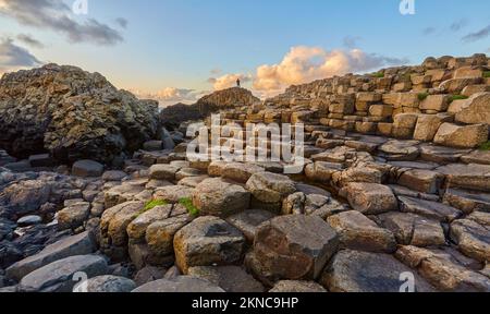 atlantic coastline with Volcanic hexagonal basalt columns of Giant`s Causeway at sunset in Northern Ireland Stock Photo